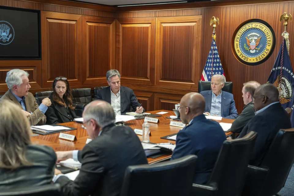 In this image provided by the White House, President Joe Biden, along with members of his national security team, receive an update on an ongoing airborne attack on Israel from Iran, as they meet in the Situation Room of the White House in Washington, Saturday, April 13, 2024. From left to right, facing Biden are, Central Intelligence Agency Director William Burns; Avril Haines, Director of National Intelligence; Secretary of State Antony Blinken and National Security Advisor Jake Sullivan. Some papers on the desk have been blurred by the source for national security reasons. (Adam Schultz/The White House via AP)