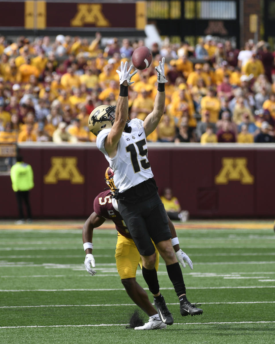 Purdue wide receiver Charlie Jones (15) catches a 28-yard pass while defended by Minnesota defensive back Justin Walley (5) during the second half of an NCAA college football game, Saturday, Oct. 1, 2022, in Minneapolis. Purdue won 20-10. (AP Photo/Craig Lassig)