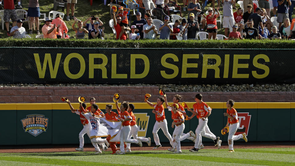 FILE - In this Sunday, Aug. 25, 2019, file photo, River Ridge, Louisiana, takes a victory lap around the field at Lamade Stadium after winning the Little League World Series Championship game against Curacao, 8-0, in South Williamsport, Pa. The 2020 Little League World Series and the championship tournaments in six other Little League divisions have been canceled because of the new coronavirus pandemic. (AP Photo/Gene J. Puskar, File)