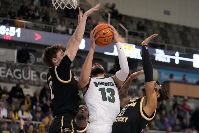 Cleveland State's Tristan Enaruna (13) shoots against Northern Kentucky's Sam Vinson (2) and Chris Brandon (21) during the first half of an NCAA college basketball game for the Horizon League men's tournament championship Tuesday, March 7, 2023, in Indianapolis.