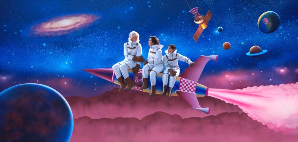 A scene from "Barbie" where Barbie and friends are sitting on a rocket while traveling through space.