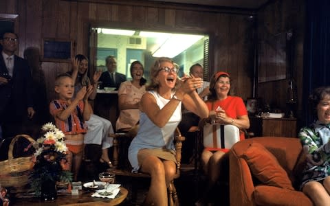 Joan Aldrin, centre, applauds her husband’s arrival back to Earth as she watches TV coverage - Credit: GETTY IMAGES