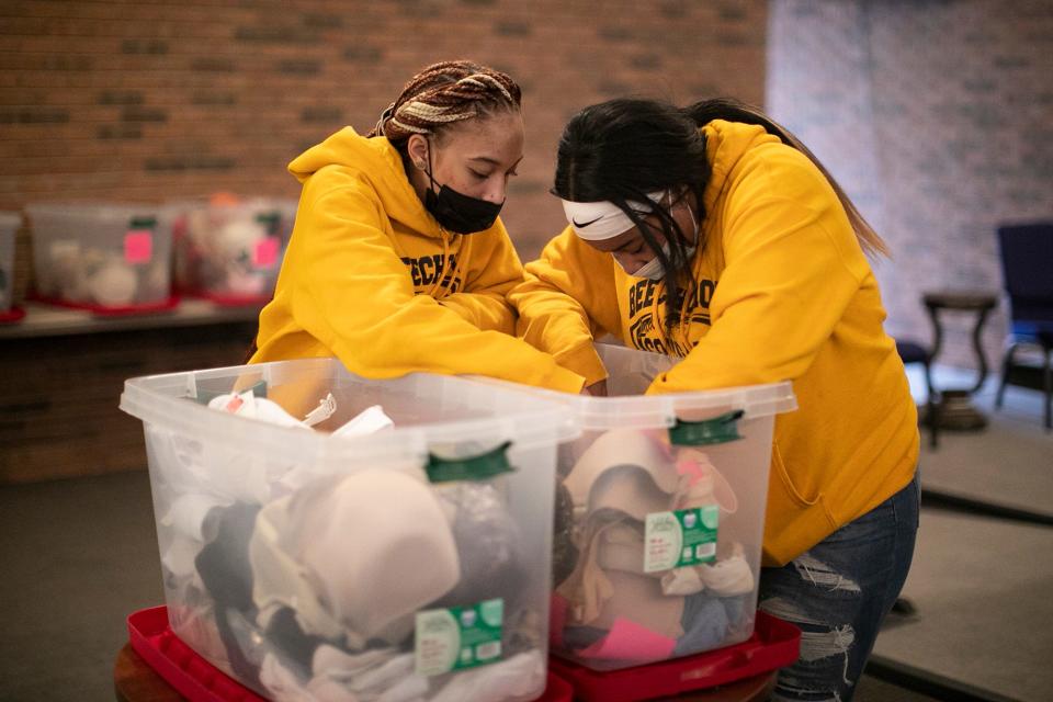 Beechcroft High School seniors Alese McNair, left, and Saraia Fisher, both 17, look for the right-sized bra for a shopper on Friday at the Church of the Good Shepherd Free Store.