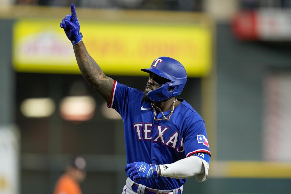 Texas Rangers' Adolis Garcia reacts after hitting a grand slam during the ninth inning of Game 6 of the baseball AL Championship Series against the Houston Astros Sunday, Oct. 22, 2023, in Houston. (AP Photo/Godofredo A. Vásquez)