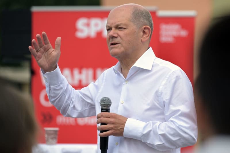 Germany's Chancellor Olaf Scholz speaks at the constituency meeting at the Bornstedt Crown Estate in Potsdam. Michael Bahlo/dpa