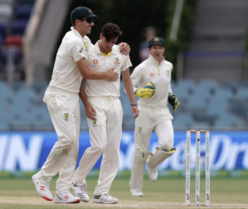 Australia's Jhye Richardson, center, is congratulated by teammate Pat Cummins, left, after taking the wicket of Sri Lanka's Dhananjaya de Silva on day 4 of their cricket test match in Canberra, Monday, Feb. 4, 2019. (AP Photo/Rick Rycroft)
