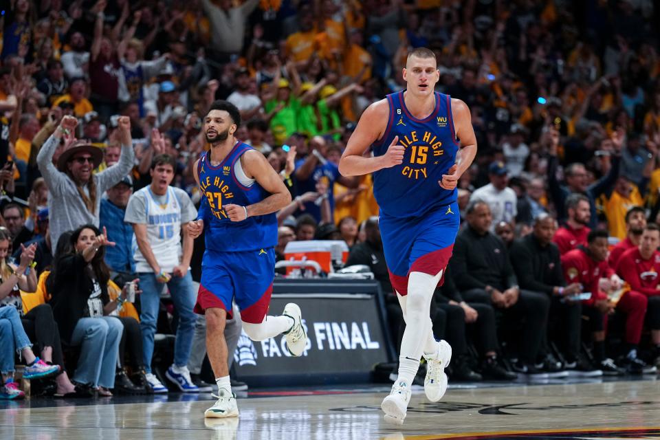 Denver Nuggets center Nikola Jokic, right, jogs on the court during the second half of Game 1 of basketball's NBA Finals against the Miami Heat, Thursday, June 1, 2023, in Denver. (AP Photo/Jack Dempsey)
