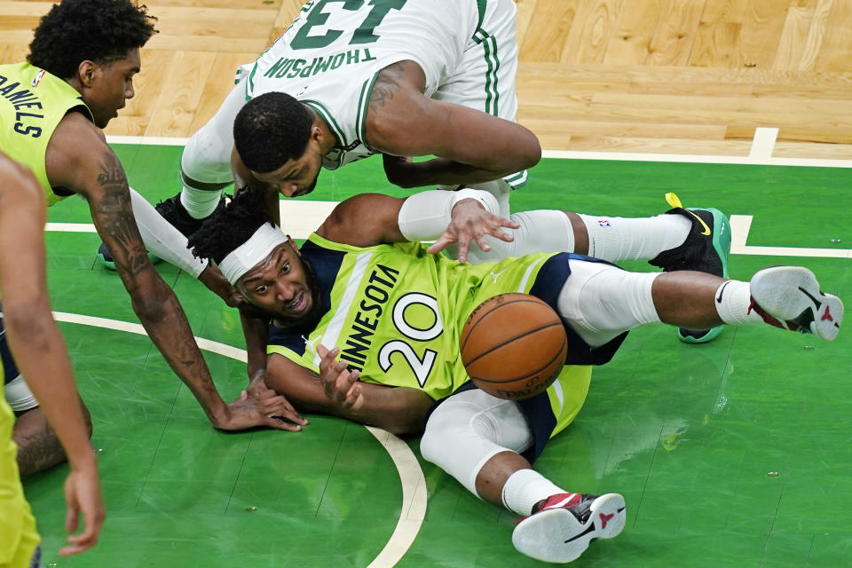 Boston Celtics center Tristan Thompson (13) comes in to tie up the ball with Minnesota Timberwolves forward Josh Okogie (20) during the second quarter of an NBA basketball game Friday, April 9, 2021, in Boston. (AP Photo/Elise Amendola)