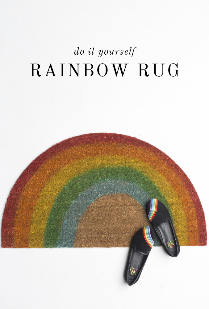 half circle fiber doormat painted with rainbow stripes there are shoes with rainbow stripes sitting on it