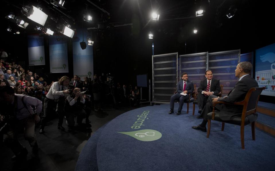 President Barack Obama talks with television hosts Jose Diaz Balart, center and Enrique Acevedo, left, during a town hall event on the importance of the benefits of the Affordable Care Act for Hispanic community, Thursday, March 6, 2014, at the Newseum in Washington. (AP Photo/Pablo Martinez Monsivais)