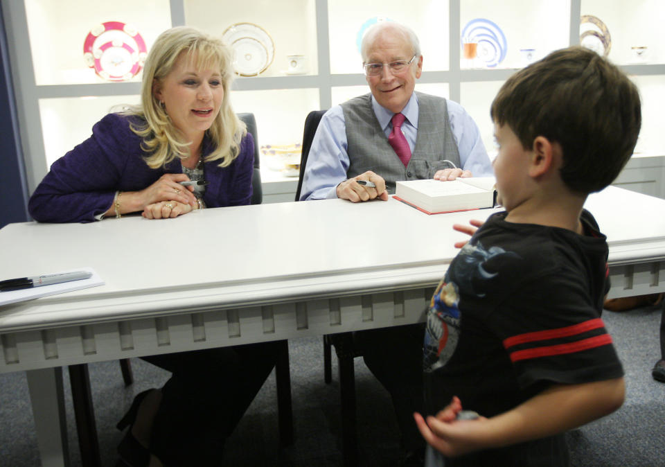 Four-year-old Joshua McBride shows his Batman shirt to Liz Cheney and her father former Vice President Dick Cheney during a tour for their book, In My Time-a Personal and Political Memoir, at the Ronald Reagan Presidential Library and Museum on Tuesday Sept. 20, 2011 in Simi Valley, California. The books covers 40 years of the former vice presidents career in Washington. (AP Photo/David McNew)