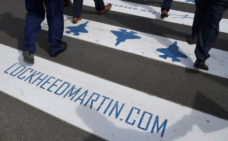 FILE PHOTO: Trade visitors are seen walking over a road crossing covered with Lockheed Martin branding at Farnborough International Airshow in Farnborough, Britain, July 17, 2018. REUTERS/Toby Melville