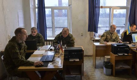 Russian and Ukrainian military officers work at the Joint Centre for Control and Coordination (JCCC) in the town of Soledar, Ukraine December 17, 2017. REUTERS/Oleksandr Klymenko