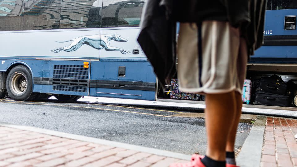 A passenger at a Greyhound bus terminal waits for a mechanic to fix a bus's flat tire in Harrisburg, PA, in July 2021. - Stephen Zenner/SOPA Images/LightRocket/Getty Images