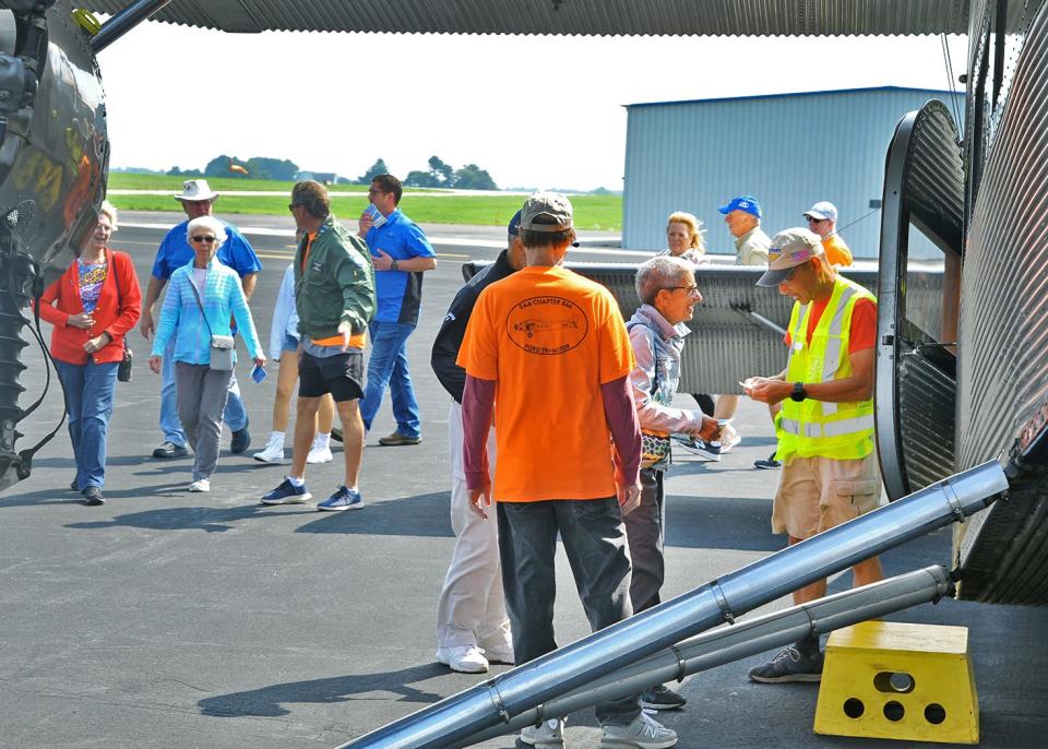 Passengers wait in line to board a Ford Tri-Motor plane at the Wayne County Airport recently. The plane, built in the 1920s, revolutionized air travel.