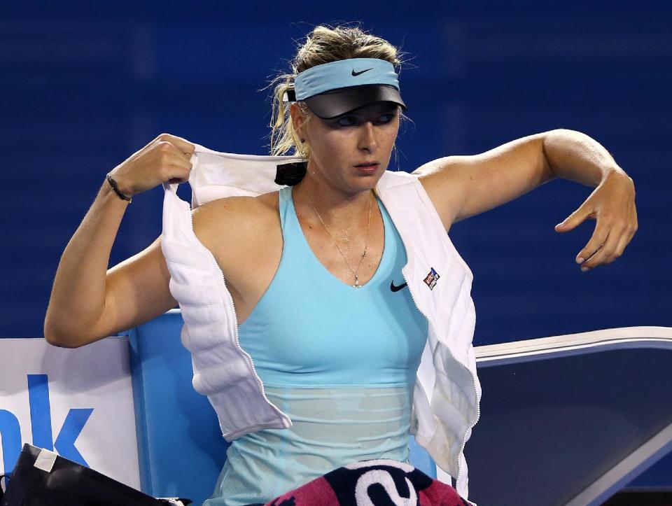 Maria Sharapova of Russia puts on ice vest between games as she plays Bethanie Mattek-Sands of the U.S. during their first round match at the Australian Open tennis championship in Melbourne, Australia, Tuesday, Jan. 14, 2014.(AP Photo/Rick Rycroft)