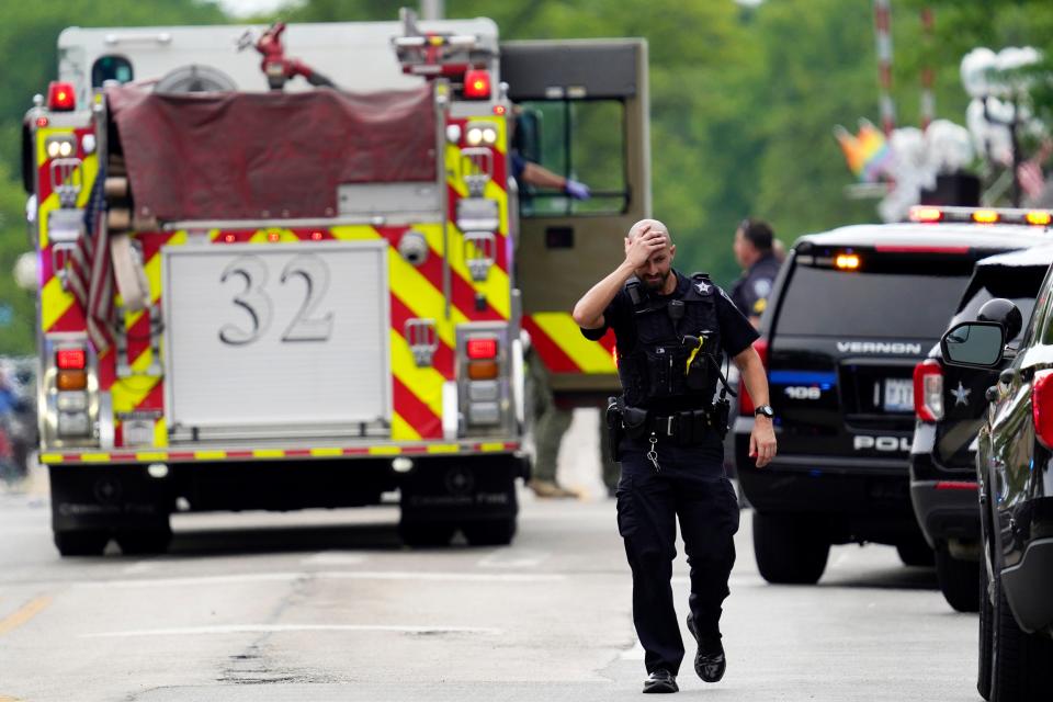 A police officer reacts as he walks in downtown Highland Park, Ill., a suburb of Chicago, Monday, July 4, 2022, where a mass shooting took place at a Highland Park Fourth of July parade. 