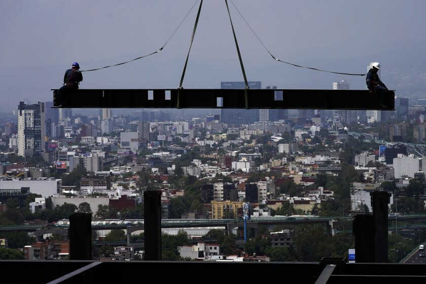 ARCHIVO - Trabajadores de la construcción están sobre una viga colgada de una grúa en un edificio residencial en obra en Ciudad de México, 17 de junio de 2022. La economía mexicana creció 1% en el segundo trimestre, informó la agencia nacional de estadísticas el viernes 29 de julio de 2022. (AP Foto/Marco Ugarte, File)