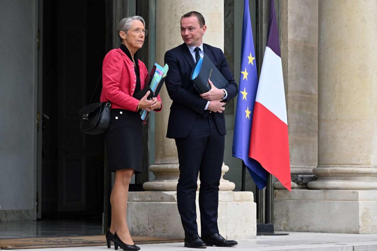 French Prime Minister Elisabeth Borne (L)  and French Labour Minister Olivier Dussopt leave after a cabinet meeting at the Elysee Palace in Paris on September 26, 2022. (Photo by Emmanuel DUNAND / AFP)