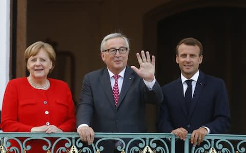 German Chancellor Angela Merkel and French President Emmanuel Macron greet EU commission president Jean-Claude Juncker