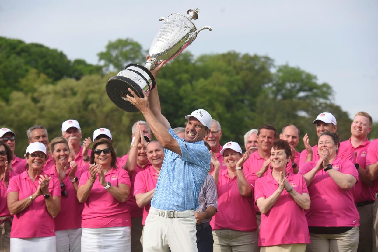 Steven Alker, center, raises the Alfred S. Bourne Trophy, Sunday, May 29, 2022, after winning the Senior PGA Championship golf tournament at Harbor Shores in Benton Harbor, Mich. (Don Campbell/The Herald-Palladium via AP)