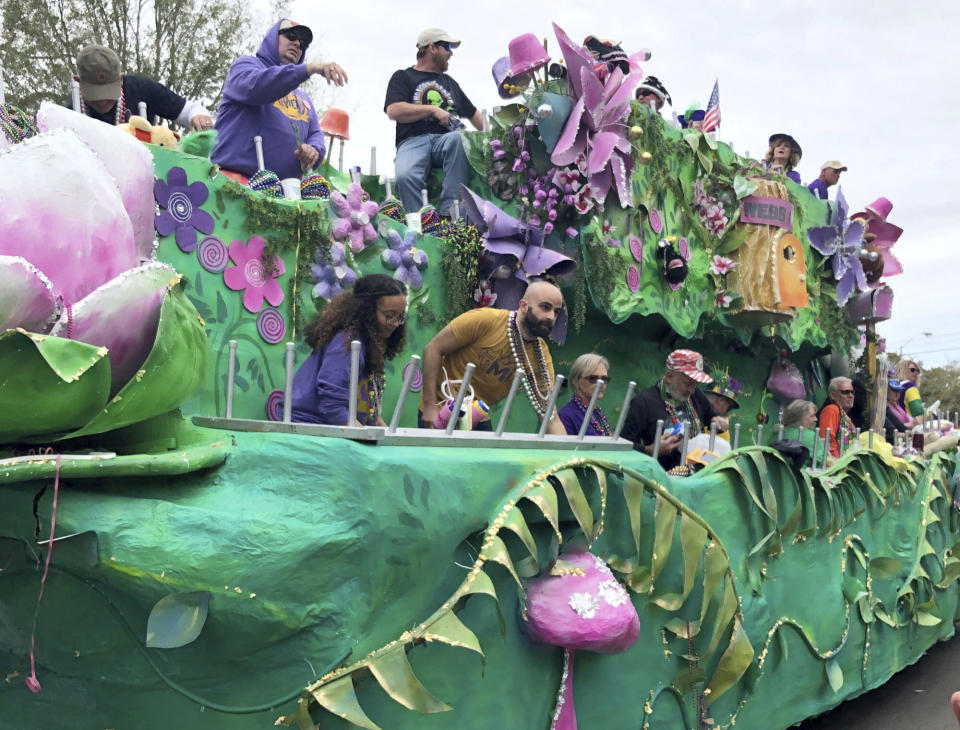 Float riders toss beads and other items to crowds during a Mardi Gras parade in Mobile, Ala., Sunday, Feb. 23, 2020. With both COVID-19 hospitalizations and vaccinations ebbing, Alabama's port city is putting on a Mardi Gras-style parade on Friday night, May 21, 2021, that will feel at least a little like the Carnival celebrations that were canceled earlier this year because of the pandemic. (AP Photo/Paul Newberry)