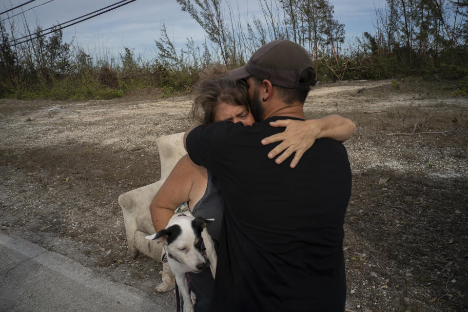 Sissel Mosvold embraces a volunteer who helped rescue her mother from her home, flooded by the waters of Hurricane Dorian, in the outskirts of Freeport, Bahamas, Wednesday, Sept. 4, 2019. Sissel’s 84-year-old mother was taken to a hospital in Freeport. Rescue crews in the Bahamas fanned out across a blasted landscape of smashed and flooded homes trying to reach drenched and stunned victims of Hurricane Dorian and take the full measure of the disaster. (AP Photo/Ramon Espinosa)