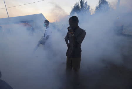 A Rohingya migrant, who recently arrived in Indonesia by boat, covers his nose as an Indonesian official sprays insecticide for mosquitos at a shelter in Kuala Langsa, in Indonesia's Aceh Province, May 19, 2015. REUTERS/Beawiharta