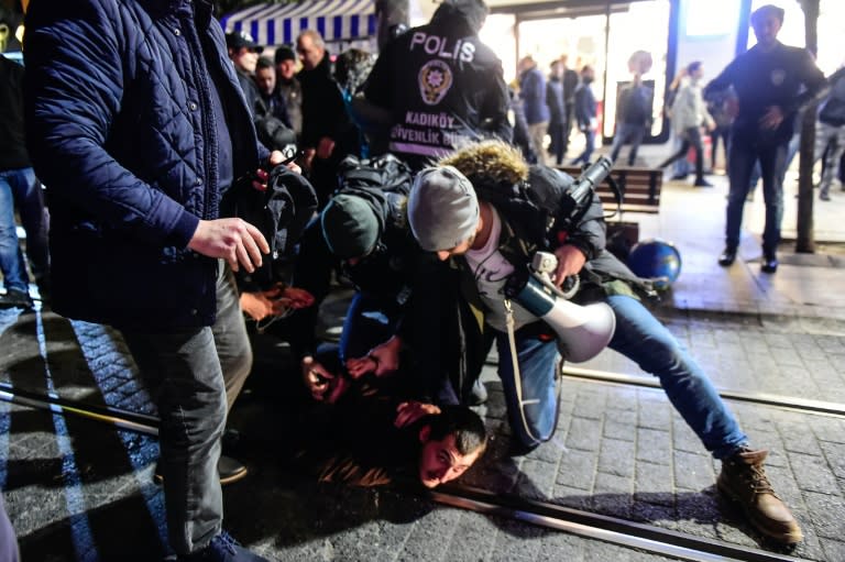 Turkish anti-riot police officers detain a protester during a demonstration against the US and Israel on December 9, 2017 in the Kadikoy district of Istanbul