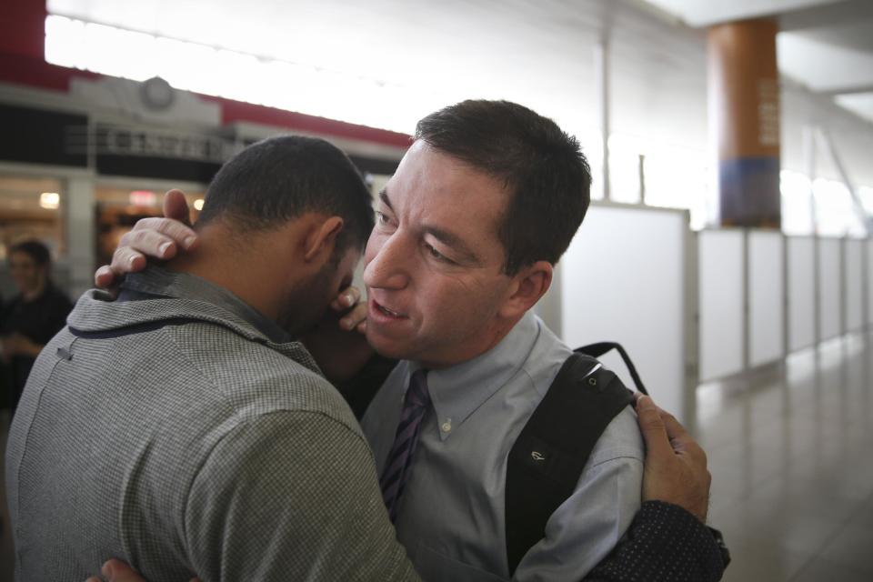 Glenn Greenwald hugs his partner David Michael Miranda, left, after arriving at John F. Kennedy International Airport, on Friday, April 11, 2014 in New York. Greenwald and Laura Poitras of the Guardian share a George Polk Award for national security reporting with The Guardian's Ewen MacAskill and Barton Gellman, who has led The Washington Post's reporting on the NSA documents. Greenwald returned to the United States for the first time since the story broke to receive the journalism award. (AP Photo/John Minchillo)