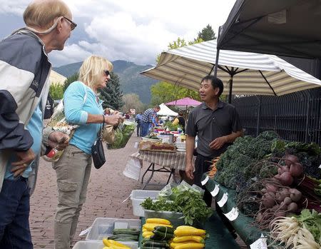 Chao Vang, a Hmong refugee from Laos who arrived in the United States in 1993, sells vegetables at a farmers' market in his adopted hometown of Missoula, Montana, U.S. August 9, 2016. REUTERS/Ellen Wulfhorst/Files