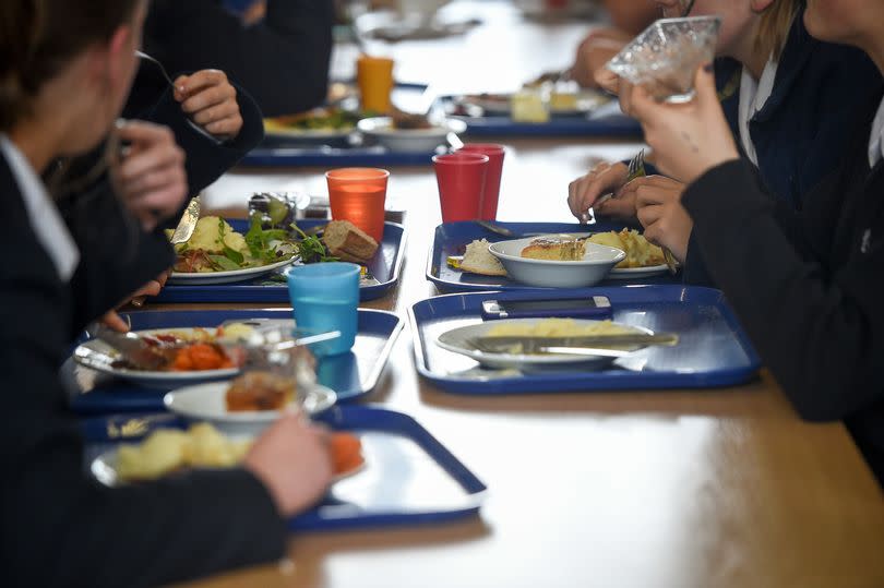 School kids of no specific age eating lunch at a table