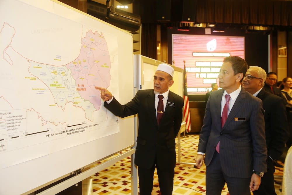 District officer Jupry Etok, also known as Jupari, talks to Election Commission chairman Datuk Azhar Azizan Harun after a press conference on the Kimanis parliamentary by-election in Putrajaya December 16, 2019. — Picture by Choo Choy May