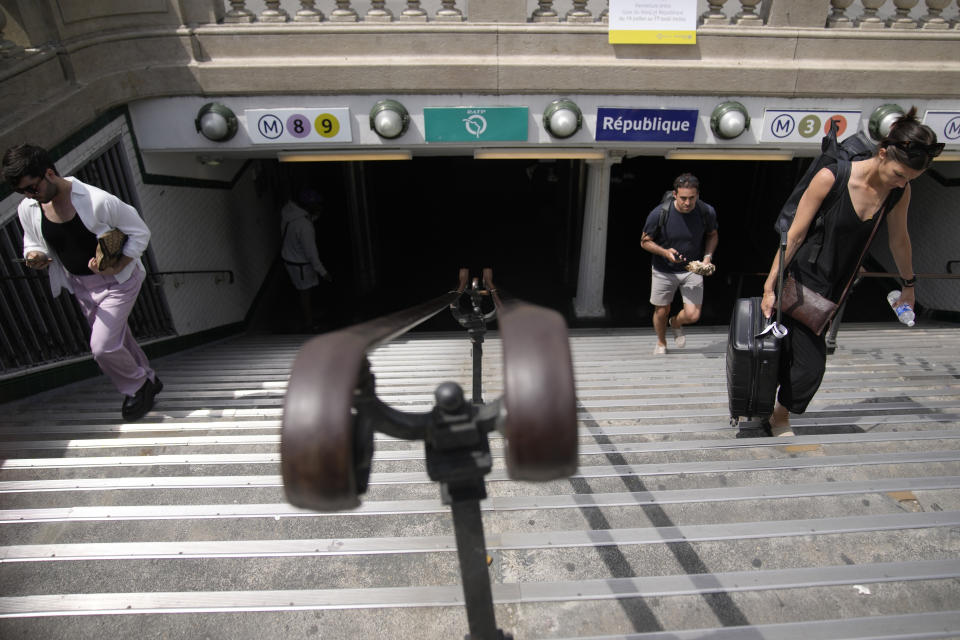 People exit a Metro station in Paris Thursday, July 20, 2023. Next year, public transport is again expected to play a starring role. Paris 2024 organizers are counting on spectators to rely overwhelmingly on the Paris region's dense network of Metro lines, suburban trains, buses and other transport to help the Games reach its target of halving its carbon footprint compared to previous editions. (AP Photo/Christophe Ena)