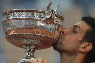 FILE - Serbia's Novak Djokovic kisses the cup after defeating Stefanos Tsitsipas of Greece during their final match of the French Open tennis tournament at the Roland Garros stadium, Sunday, June 13, 2021 in Paris. Djokovic won 6-7 (6), 2-6, 6-3, 6-2, 6-4. Rafael Nadal and Novak Djokovic are both entered in the French Open, making it the first Grand Slam tournament with both of them in the field since last year’s French Open. (AP Photo/Michel Euler, File)