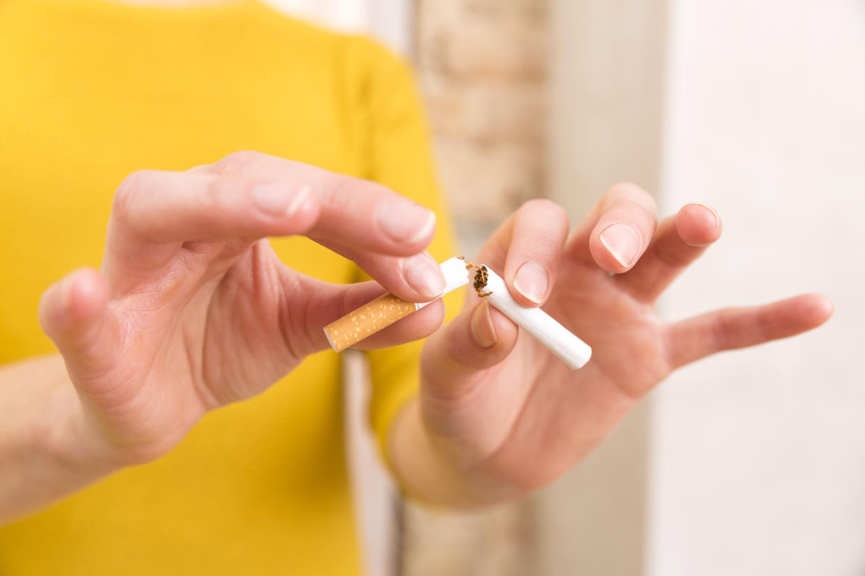 Young woman is breaking a cigarette, quit smoking concept