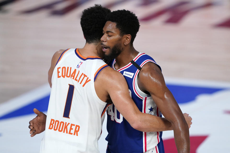 Phoenix Suns guard Devin Booker, left, greets Philadelphia 76ers forward Glenn Robinson III, right, after an NBA basketball game Tuesday, Aug. 11, 2020, in Lake Buena Vista, Fla. (AP Photo/Ashley Landis, Pool)