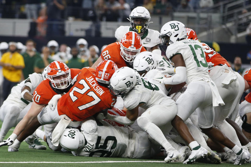 Oklahoma State running back Dezmon Jackson (27) is stopped short of the goal line by Baylor defensive lineman Gabe Hall (95) and safety Jalen Pitre (8) in the second half of an NCAA college football game for the Big 12 Conference championship in Arlington, Texas, Saturday, Dec. 4, 2021. (AP Photo/Tim Heitman)