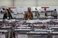 An employee walks past ballot boxes at Central Election Committee counting center in Fushe Kosove, Kosovo on Monday, Oct. 7, 2019. Kosovo's opposition parties have won a snap election, overcoming the former independence fighters who have governed the country since its war 20 years ago. With 96% of the votes counted Monday the left-wing Movement for Self-Determination Party, or LVV, has 26% of the votes, one percentage point more than the conservative Democratic League of Kosovo, or LDK, also formerly in opposition. (AP Photo/Visar Kryeziu)