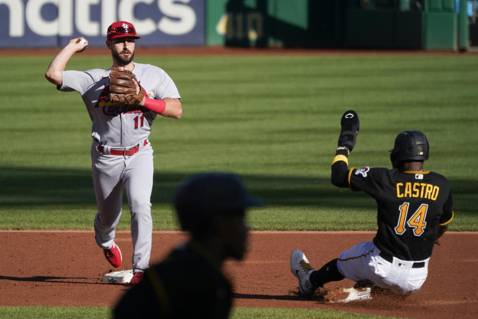 St. Louis Cardinals shortstop Paul DeJong (11) relays the ball as Rodolfo Castro (14) is forced out on the front half of the double play Ke'Bryan Hayes, center, hit into during the first inning of a baseball game, Wednesday, Oct. 5, 2022, in Pittsburgh. (AP Photo/Keith Srakocic)