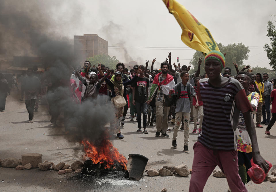 Sudanese men burn tires during a demonstration to commemorate the third anniversary of a deadly crackdown carried out by security forces on protesters during a sit-in outside the army headquarters, in Khartoum, Sudan, Friday, June 3, 2022. Talks aiming at ending Sudan’s ongoing political deadlock began Wednesday, June 8, 2022, the United Nations said, although the country's main pro-democracy alliance is boycotting them over a continued police crackdown on those protesting last October's military coup. (AP Photo/ Marwan Ali)