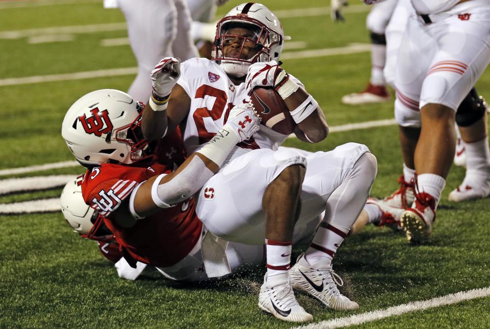 Utah linebacker Kavika Luafatasaga, left, tackles Stanford running back Bryce Love (20) in the first half during an NCAA college football game Saturday, Oct. 7, 2017, in Salt Lake City. (AP Photo/Rick Bowmer)