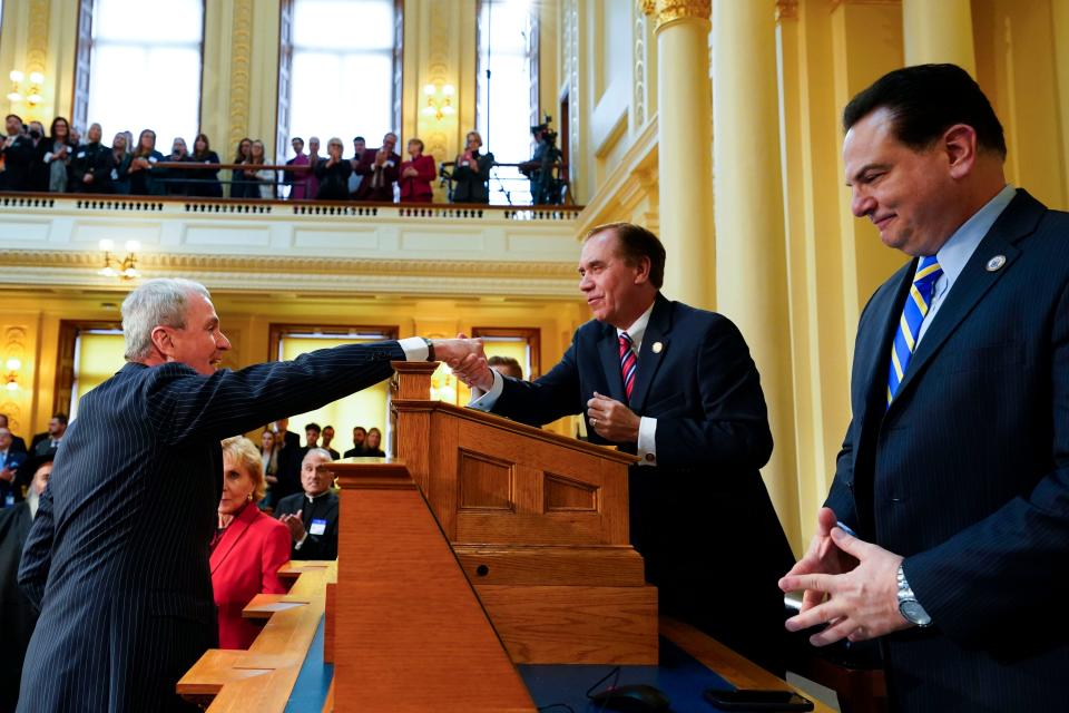 (from left) Gov. Phil Murphy shakes hands with Assembly Speaker Craig Coughlin as Senate President Nick Scutari looks on before Murphy's budget address at the New Jersey Statehouse on Tuesday, Feb. 28, 2023.