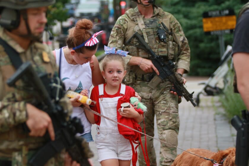 HIGHLAND PARK, ILLINOIS - JULY 04: Law enforcement escorts a family away from the scene of a shooting at a Fourth of July parade on July 4, 2022 in Highland Park, Illinois. Police have detained Robert "Bobby" E. Crimo III, 22, in connection with the shooting in which six people were killed and 19 injured, according to published reports. (Photo by Mark Borenstein/Getty Images)