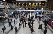 Commuters look up at the departure boards as they make their way home in London, Friday, Oct. 23, 2020. In much of Europe, city squares and streets, be they wide, elegant boulevards like in Paris or cobblestoned alleys in Rome, serve as animated evening extensions of drawing rooms and living rooms. As Coronavirus restrictions once again put limitations on how we live and socialize, AP photographers across Europe delivered a snapshot of how Friday evening, the gateway to the weekend, looks and feels. (AP Photo/Alastair Grant)