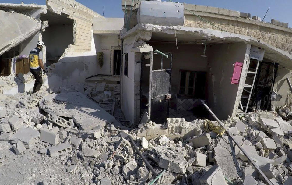 This photo released by the opposition Syrian Civil Defense rescue group, also known as White Helmets, which has been authenticated based on its contents and other AP reporting, shows a civil defense worker inspecting destroyed buildings after airstrikes hit the town of Jarjnas, in Idlib province, Syria. Syrian opposition activists said government warplanes have struck towns and villages in the northwestern province of Idlib including one near a Turkish observation post. (Syrian Civil Defense White Helmets via AP)