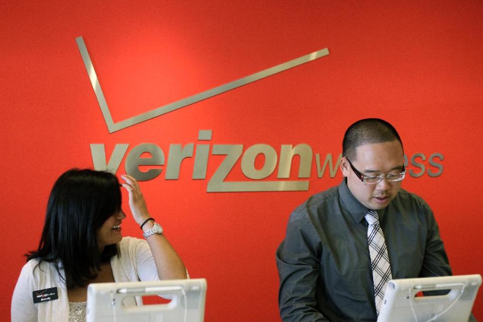 FILE- In this Tuesday, June 12, 2012, file photo, two Verizon workers take orders at a Verizon store in Mountain View, Calif. Verizon Communications Inc., parent of the country’s largest cellphone carrier, on Thursday, July 19, 2012, said its net income rose 13 percent in the second quarter as its wireless arm pulled in record profits. (AP Photo/Paul Sakuma, File)