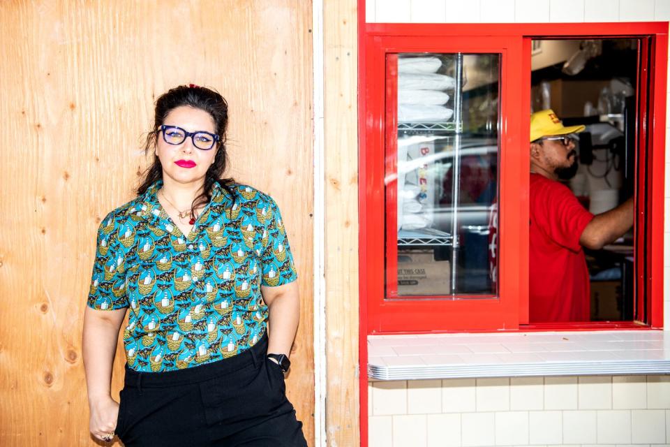 A portrait of first-time customer Rose Ghavami waiting for her order at the pickup window of Irv's Burgers.