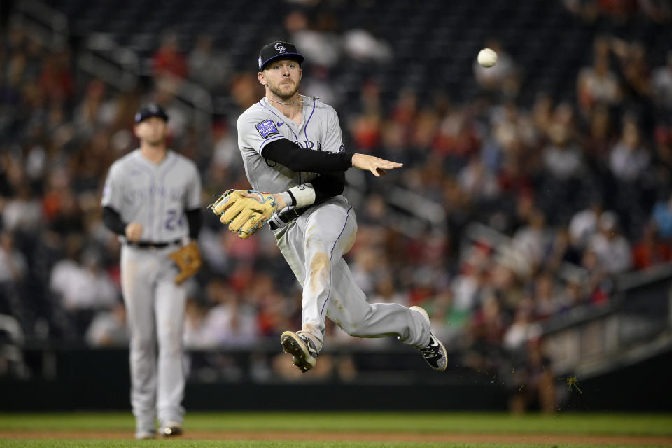 Colorado Rockies shortstop Trevor Story throws to first but is unable to put out Washington Nationals' Lane Thomas who singled during the sixth inning of a baseball game on Friday, Sept. 17, 2021, in Washington. Story was charged with a throwing error on the play which enabled Thomas reach second. (AP Photo/Nick Wass)