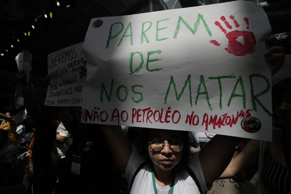 FILE - An activist shows a sign that reads in Portuguese "Stop killing us. No to oil in the Amazon", during a protest by social movements against oil exploration at the mouth of the Amazon River, during the Amazon Dialogue meetings at the Hangar convention center, in Belem, Brazil, Aug. 6, 2023. The two-day Amazon Summit opens Tuesday, Aug. 8, 2023, in Belem, where Brazil hosts policymakers and others to discuss how to tackle the immense challenges of protecting the Amazon and stemming the worst of climate change. (AP Photo/Eraldo Peres)